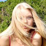 Third pic of Petite blonde babe Skye shows off her perky body as she strips outdoors down to little pink g-string