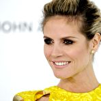 Fourth pic of Heidi Klum posing in yellow short dress, shows her legs
