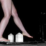 Fourth pic of Naked handcuffed slave girl Alyssa standing on the electrified floor in the dungeon.