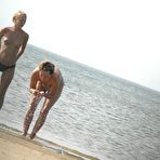 First pic of Young nudists rub oil on each other's naked bodies