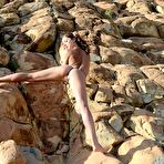 Second pic of Cute babe Foxi Di poses naked on the rocks over the ocean and shows off shaved kitty