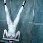 Third pic of SexPreviews - Kel Bowie is bound in wooden stock her ass spanked red and tits clamped