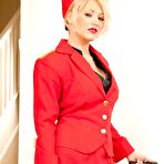 First pic of Blonde babe Sarah Saint in red uniform and black stockings bares her smooth pussy