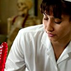 Second pic of Nurse Isis Love in white uniform pulls down her black panties for fun with fucking machines