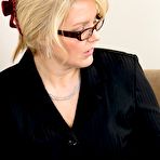 First pic of Businesswoman GILF teasing her completely smooth pussy on a couch - IamXXX.com