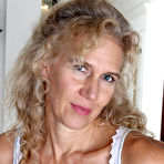 First pic of Curly-haired blonde MILF fingering her dripping pussy on a couch - IamXXX.com