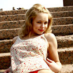 Fourth pic of Startling blonde kitten in red high-heeled boots demonstrates her nude body on the age-old stone steps in a desert place. gallery