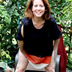 Third pic of Naughty American MILF fooling around in the garden without panties