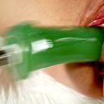 Third pic of Pinky Lee takes green power dildo deep in her love tunnel on fluffy bed cover.