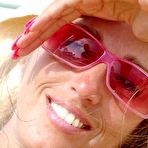 Second pic of Lori Anderson in pink shades and yellow bikini demonstrates her hairy arms in the sun