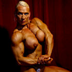 Second pic of Big titted muscle woman Nicole Ball takes off her bikini to pose naked in the semi-dark