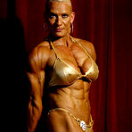 Third pic of Big titted muscle woman Nicole Ball takes off her bikini to pose naked in the semi-dark