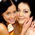 Fourth pic of Older lady and her young lesbian lover kiss while they get naked on a bed