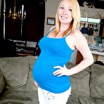 First pic of Blonde girl displays her swollen belly while getting completely naked