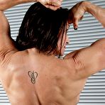 Fourth pic of Female bodybuilder flexes after getting naked on a mat in black socks