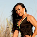 Second pic of Asian bodybuilder Tram Nguyen flexes in the outdoors while wearing dresses