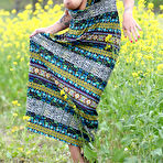 Fourth pic of Hot and horny Olivia fingers her bald pussy while spreading topless outdoors