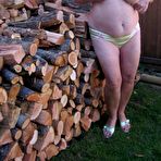 Third pic of Brazen older granny strips off by the wood pile to show off BBW tits & big ass