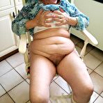 First pic of Horny granny Caro sticks a banana inside her natural pussy on kitchen chair