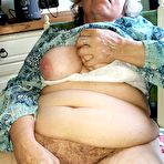 Second pic of Horny granny Caro sticks a banana inside her natural pussy on kitchen chair