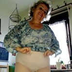 Fourth pic of Horny granny Caro sticks a banana inside her natural pussy on kitchen chair