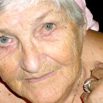 Fourth pic of Obese grandmother licks her own nipples as she strips naked in living room