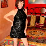 First pic of Older brunette Anne Swinger unveils her tits before showing her bald cunt