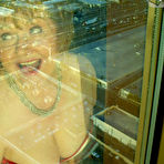 Second pic of Mature woman Busty Bliss looses her big tits from a corset by her condo window