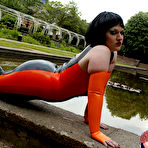 Third pic of Brunette chick models latex clothing and over the knee boots near some water
