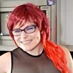 First pic of Thick redhead removes leather attire to pose nude before donning nurse garb