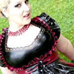 Third pic of Overweight blonde Darkwing Zero models on a lawn in a rubber dress