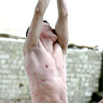 Second pic of Russian mistress tortures a restrained male sub during outdoor action