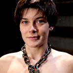 Third pic of Brunette dyke is flogged by a man while restrained in a dungeon