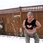 Second pic of Naughty granny Girdle Goddess strips to her stockings and boots while it snows