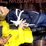 Second pic of Shinynylonartsbound | Sandra tied and gagged overhead with ropes and a ballgag overhead prepared to be hunged up by Stella both wearing sexy shiny nylon rainwear (Pics) PART1of 2