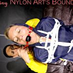 Fourth pic of Shinynylonartsbound | Sandra tied and gagged overhead with ropes and a ballgag overhead prepared to be hunged up by Stella both wearing sexy shiny nylon rainwear (Pics) PART1of 2